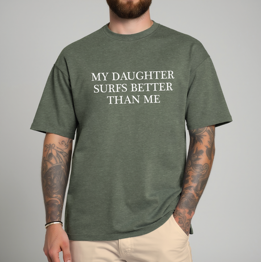 Person wearing a green t-shirt with text 'MY DAUGHTER SURFS BETTER THAN ME' on a gray background